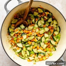 Sauteing onions, carrots, celery, garlic, and zucchini in soup pot.