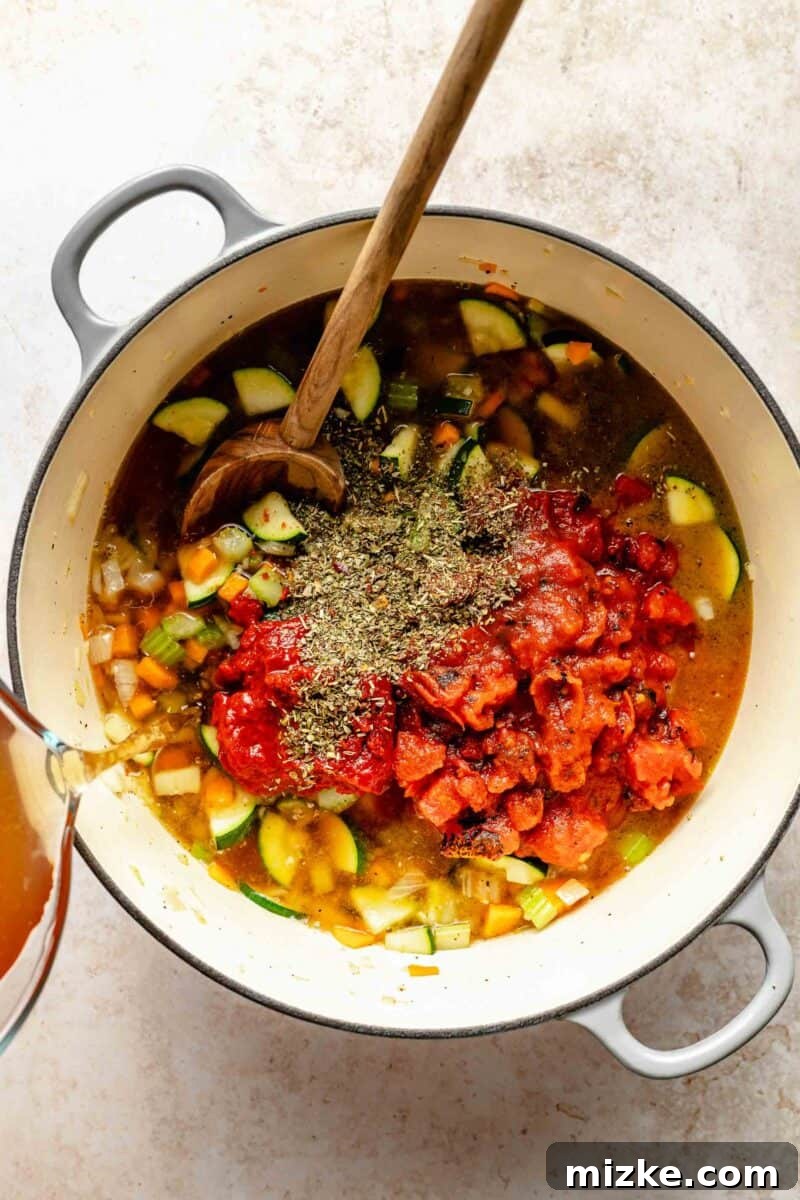 Loaded with tender veggies, beans, and pasta in a flavorful, tomato-y broth, minestrone soup is the perfect vegetarian main. Stirring in diced tomatoes, vegetable broth, tomato paste, and Italian seasoning into the sautéed vegetables in the soup pot.