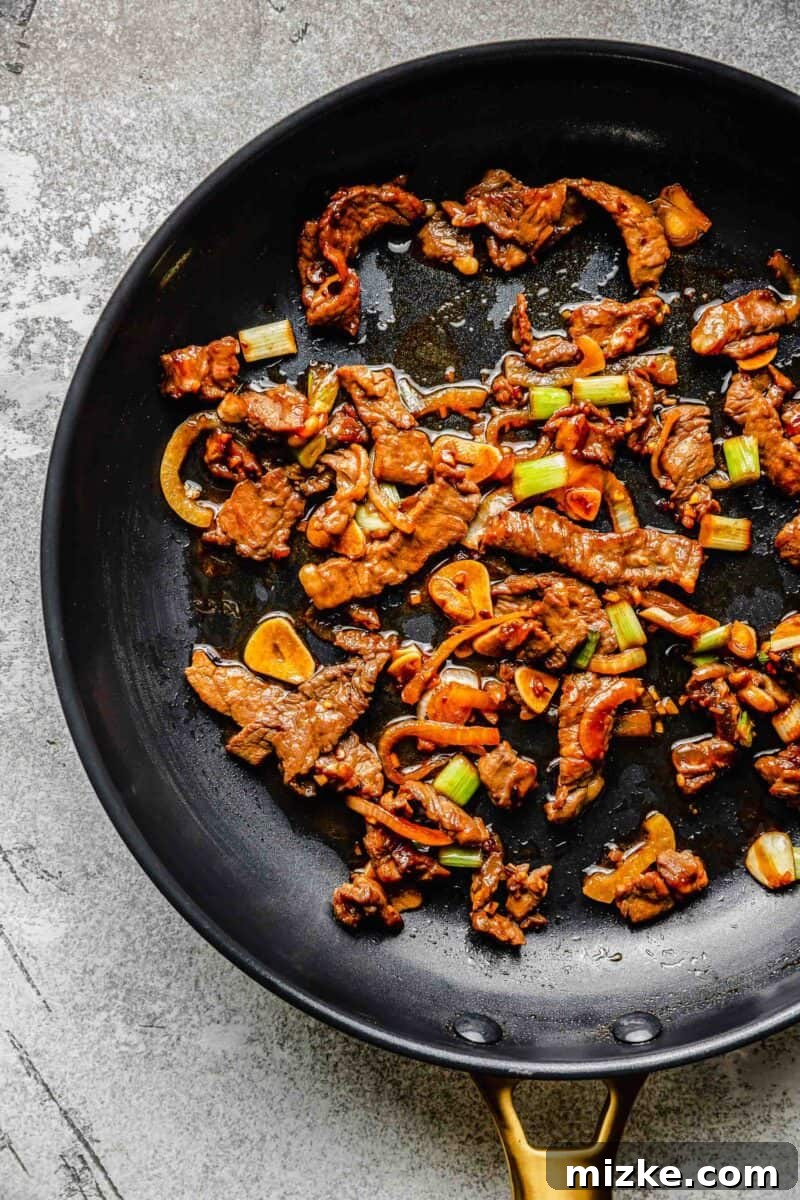 Thinly sliced beef, garlic, onions, and scallions are marinated in a flavorful sauce and fried to perfection in this Korean beef bulgogi. Sautéing marinated beef and vegetables for Korean beef bulgogi in a hot frying pan.