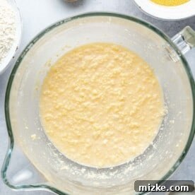 Wet ingredients for cornbread batter in a mixing bowl.