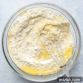 Combining dry ingredients for cornbread batter.