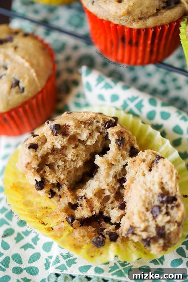 Mouth-watering Banana Peanut Butter Chocolate Chip Muffin Close-up A close-up shot of a warm Banana Peanut Butter Chocolate Chip Muffin, split open to reveal its moist interior, melted chocolate chips, and banana pieces. Ready to be enjoyed.