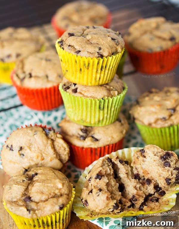 Plated Banana Peanut Butter Chocolate Chip Muffins Three Banana Peanut Butter Chocolate Chip Muffins arranged artfully on a white plate, with a focus on their appealing texture and golden-brown crust. Ready to serve.
