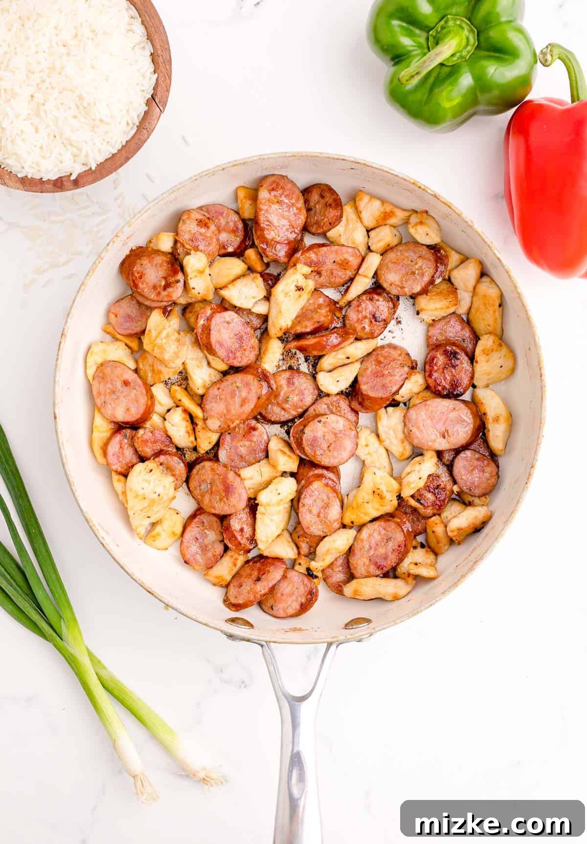 Hearty Chicken and Sausage Jambalaya 4 chicken and sausage cooked and browned in a white skillet