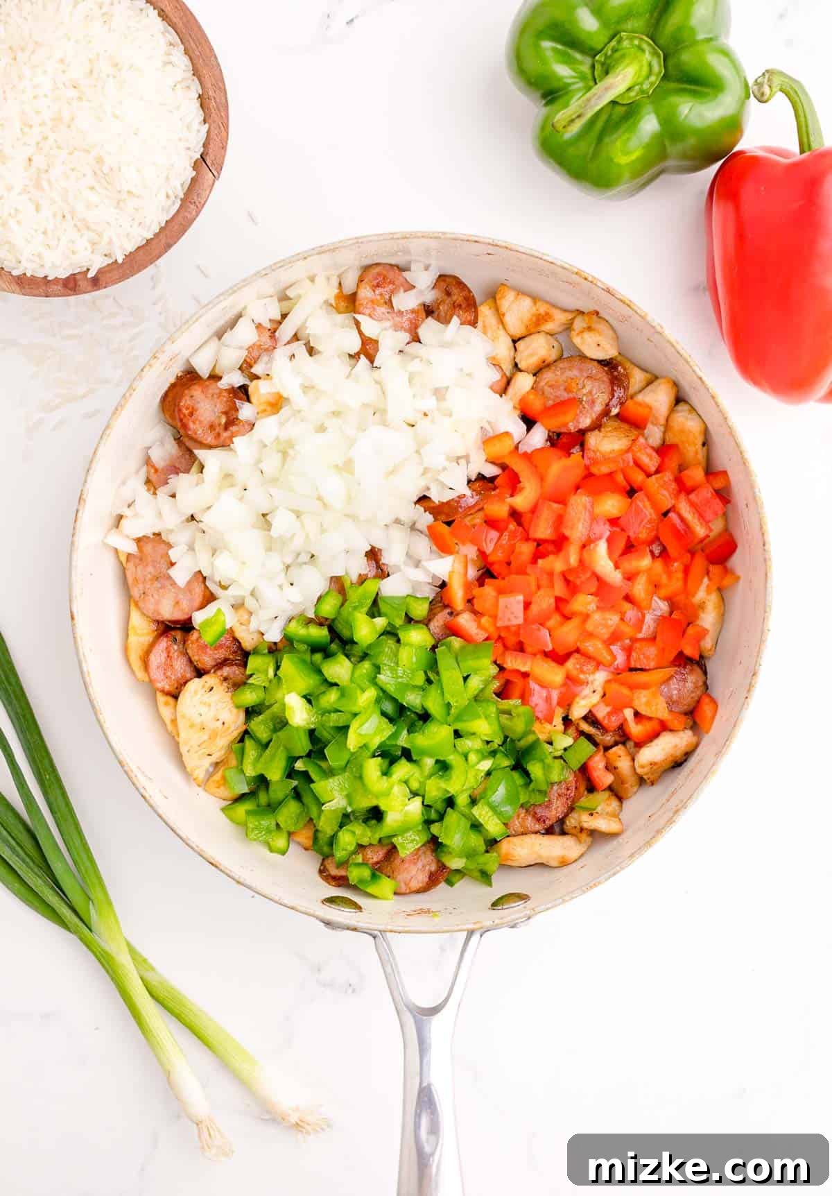 Hearty Chicken and Sausage Jambalaya 5 red and green bell peppers along with white onion added to the skillet with sausage and chicken