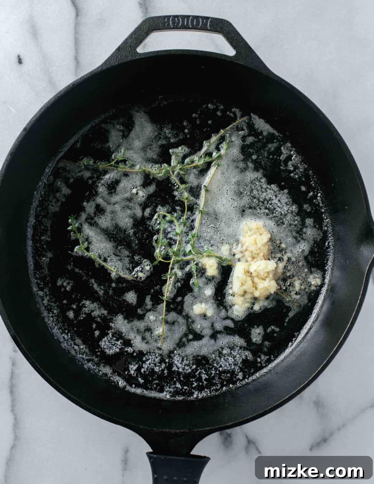 Unlocking Oyster Mushroom Potential 5 Melted butter, freshly minced garlic, and fragrant thyme sprigs sizzling in a cast iron skillet, forming the flavor base for cooking mushrooms.
