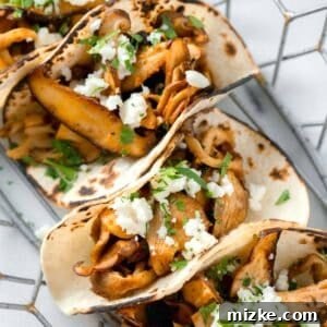 oyster mushroom tacos stacked in a wire basket with fresh parsley and cotija cheese garnished on top