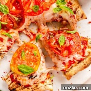 sliced wedges of grilled caprese pizza pulled from the rest of the pizza
