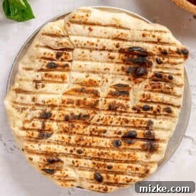 charred and browned pizza dough on a metal pizza pan