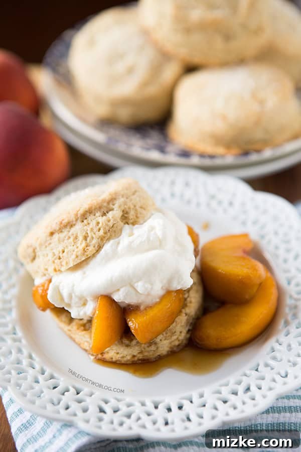 Boozy Peaches and Honey Cream Shortcakes | tablefortwoblog.com Boozy Peaches and Honey Cream Shortcakes with a golden brown biscuit and fresh fruit