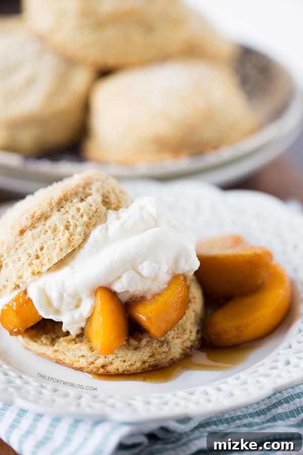 Detailed shot of the fluffy biscuit texture and the rich honey cream in a Boozy Peaches and Honey Cream Shortcake