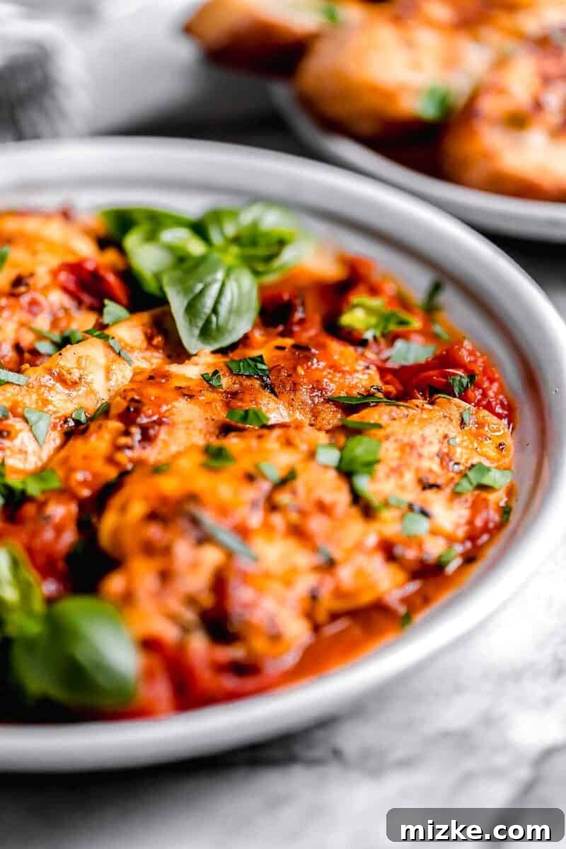 Sun-Kissed Tomato-Herb Chicken 3 Side view of perfectly cooked chicken tenders generously coated in a rich tomato herb sauce.