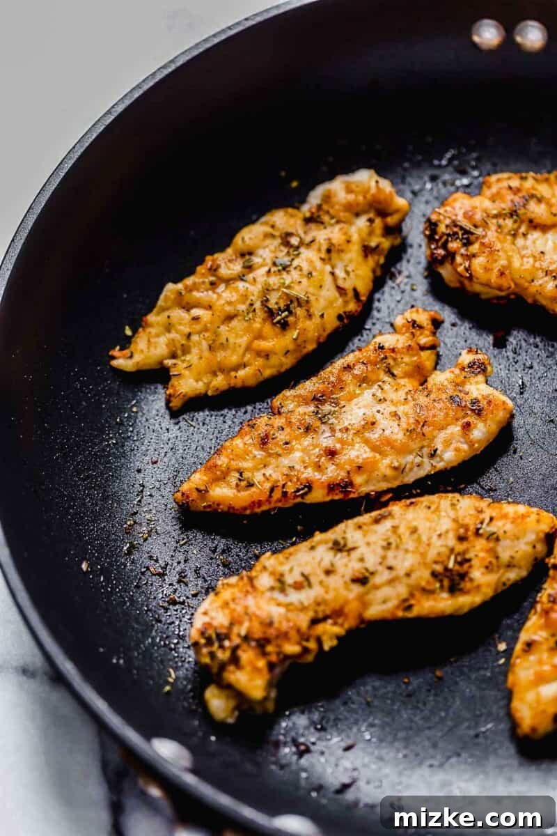 Sun-Kissed Tomato-Herb Chicken 5 Seasoned chicken tenders browning in a nonstick skillet.