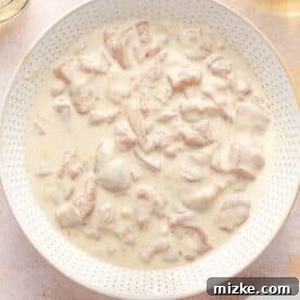 chicken thigh pieces marinating in a flour mixture