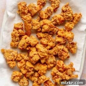 deep fried chicken pieces on a paper towel-lined plate