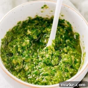 basil pesto in a small gold rimmed bowl with a white spoon