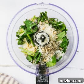 ingredients for basil pesto in the bowl of a food processor