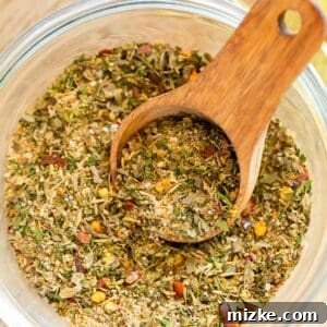 greek seasoning in a clear bowl with a wooden spoon