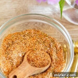 Signature Adobo Spice Blend 4 adobo seasoning in a clear bowl with a wooden spoon