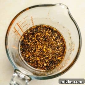 Ingredients for the sauce mixture for green bean chicken stir fry in a glass measuring cup, ready to be whisked.