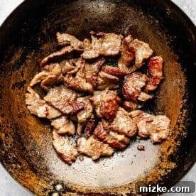 Sizzling Beef and Green Bean Stir-Fry 8 Thinly sliced flank steak pieces searing and browning in a hot wok, achieving a delicious crust.