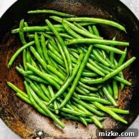 Sizzling Beef and Green Bean Stir-Fry 9 Fresh green beans getting charred and cooked to perfection in a wok, developing a tender-crisp texture.
