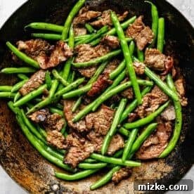 Sizzling Beef and Green Bean Stir-Fry 10 Seared beef and cooked green beans combined in a wok, ready for the final sauce.