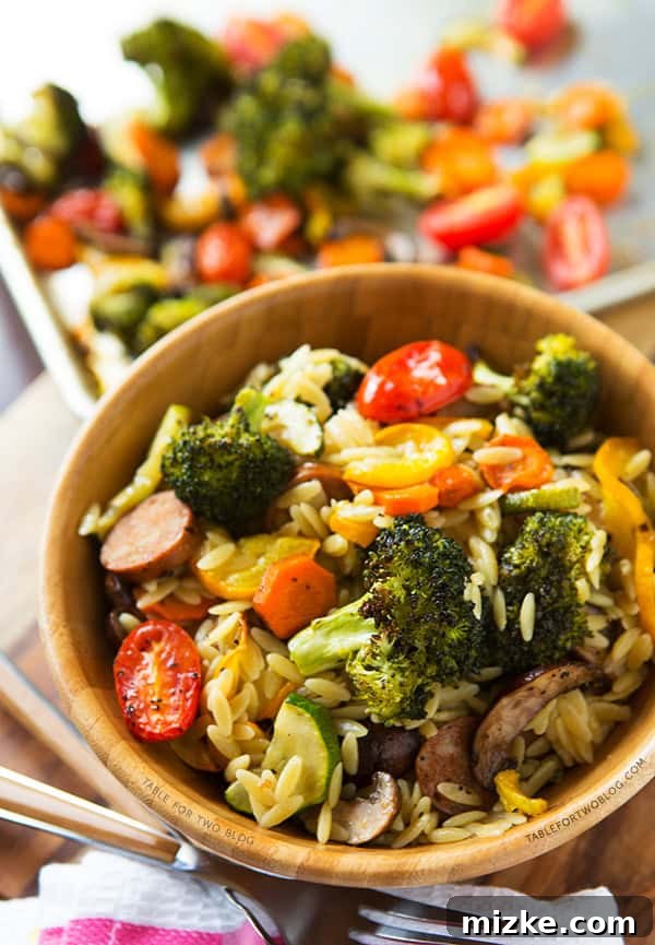 Savoring Roasted Vegetables and Andouille Orzo Close-up shot of Roasted Vegetables and Andouille Orzo, highlighting the rich and savory sausage alongside tender vegetables and creamy orzo. | tablefortwoblog.com