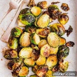 A close-up of a bowl of delicious roasted garlic Brussels sprouts.
