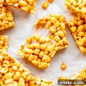 A single cereal bar is being split in half, showcasing its gooey texture.