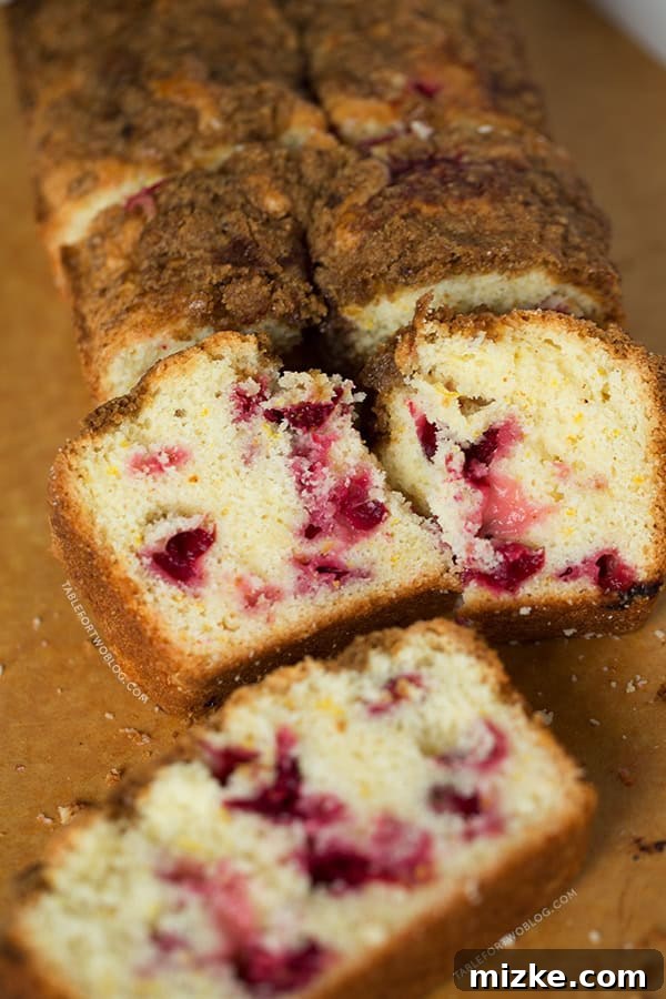 A beautifully sliced Cranberry Orange Loaf, showcasing vibrant cranberries and a golden crumb, ready for breakfast.