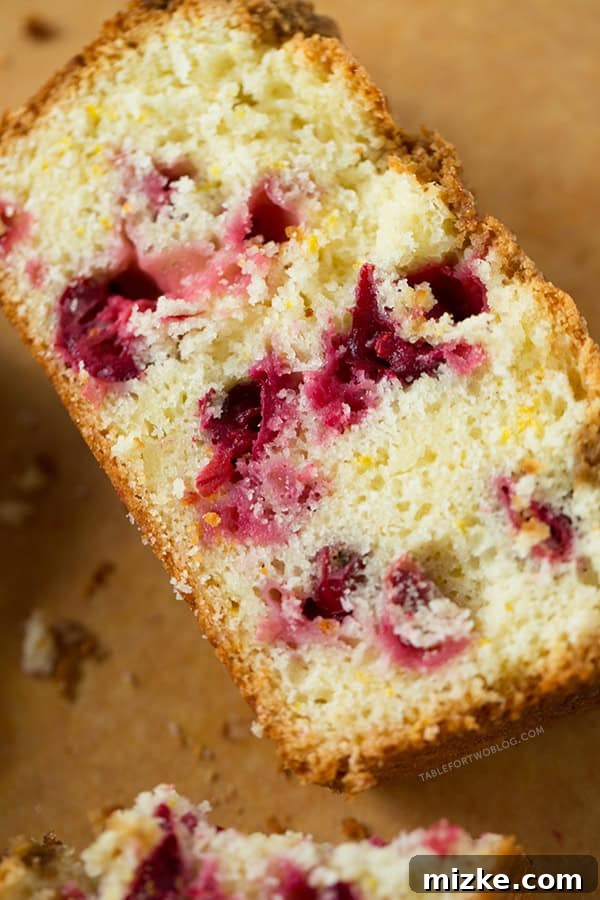 A freshly baked Cranberry Orange Loaf cooling on a wire rack, steam gently rising, promising a delicious treat.