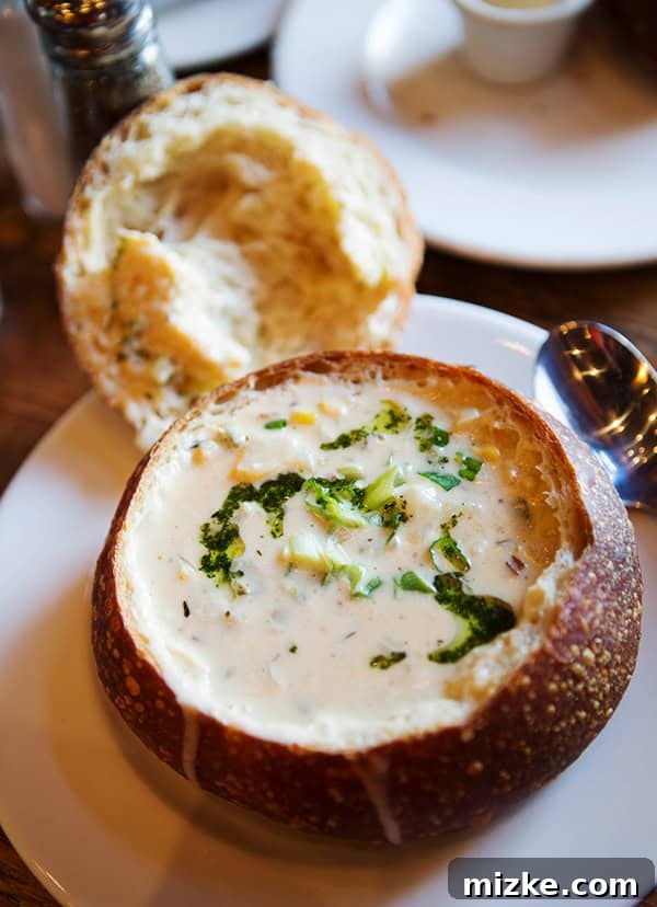Sourdough bread bowl filled with savory chowder, a must-try. Close-up of the rich and creamy crab and corn chowder.