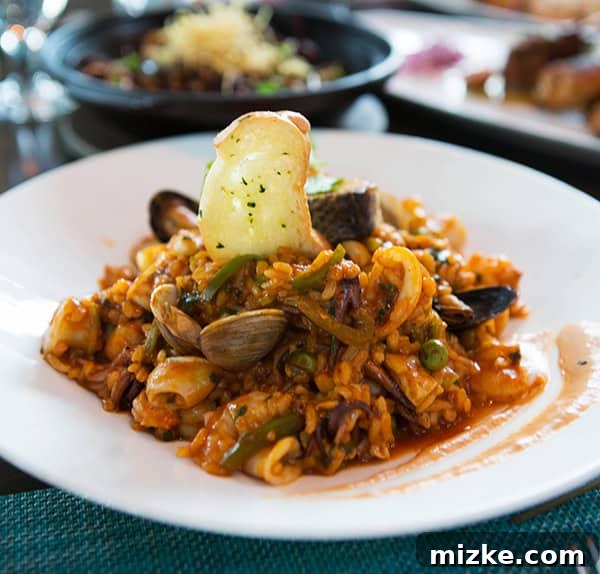 A flavorful and satisfying paella-style dish. A large pan of paella-like seafood and rice dish.