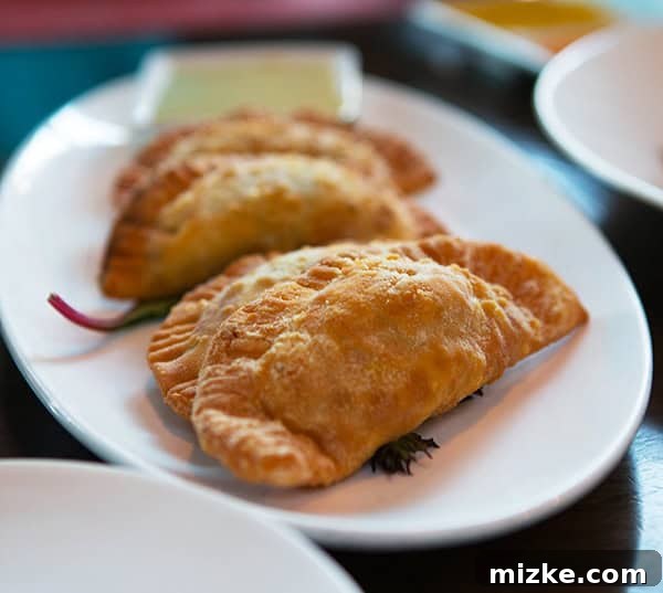 Enjoy a variety of delicious empanadas. A platter of assorted empanadas, each with a unique filling.