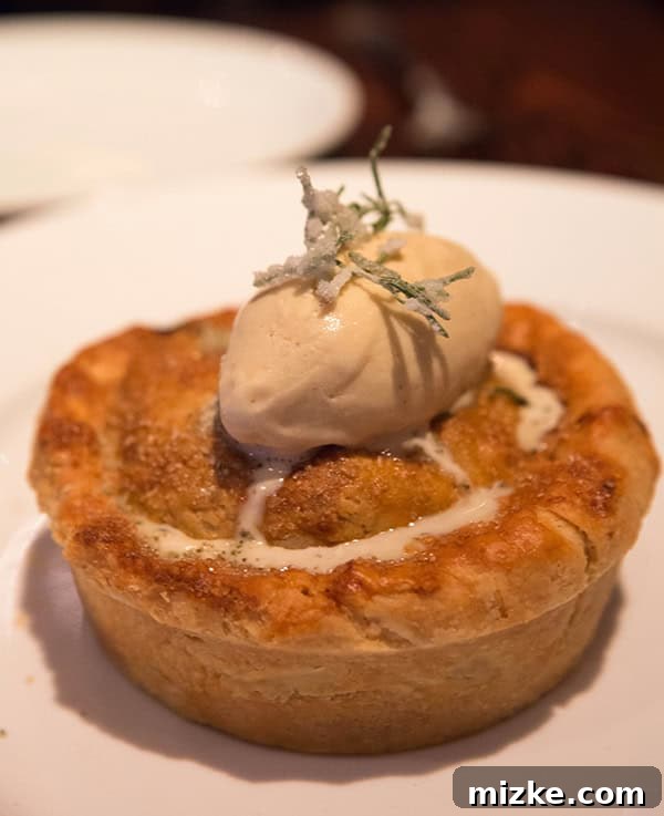 Decadent peach pie with brown butter ice cream at Wayfare Tavern. A slice of warm peach pie topped with a scoop of brown butter ice cream and candied rosemary.