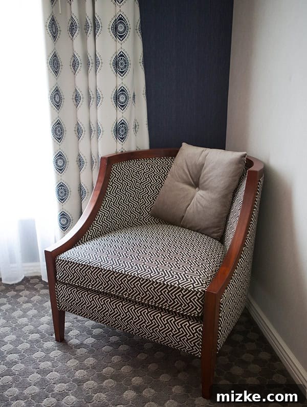 A chic and comfortable armchair in the suite. A stylish patterned accent chair in a hotel suite.