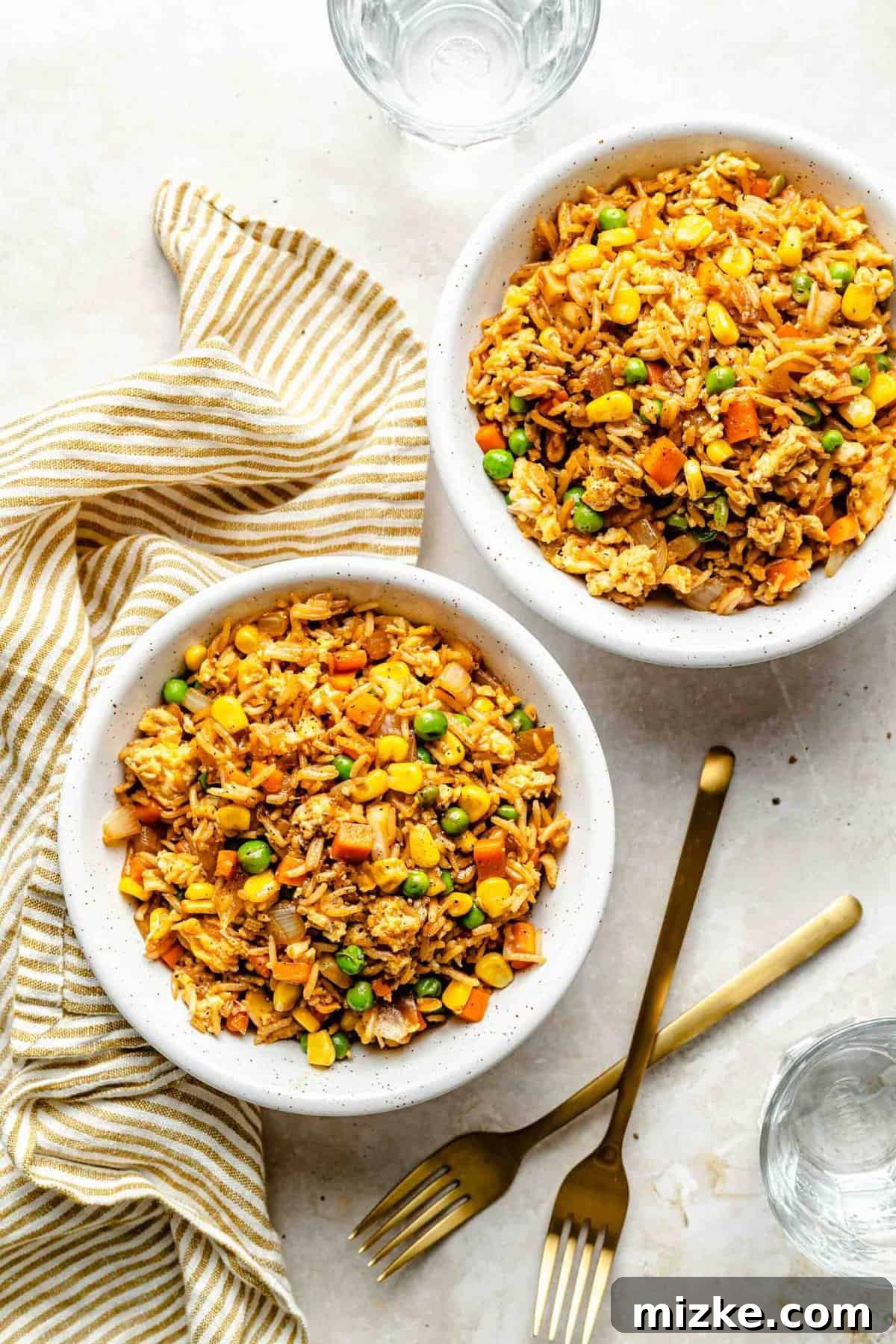 Delicious homemade fried rice, perfectly plated and ready to enjoy. Multiple bowls of vegetable fried rice, garnished and ready to serve, viewed from above.