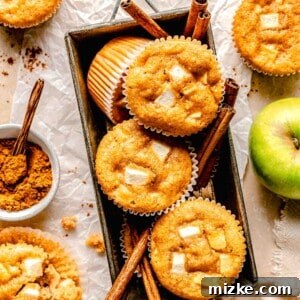 Apple cinnamon muffins in a loaf pan with cinnamon sticks.