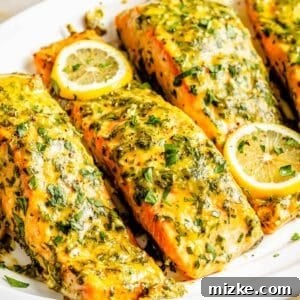 Sweet & Savory Dijon Salmon 5 four pieces of honey dijon salmon on a white plate with lemon slices on top