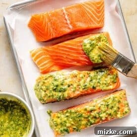 Sweet & Savory Dijon Salmon 7 salmon pieces brushed with honey dijon garlic sauce on a parchment lined baking sheet