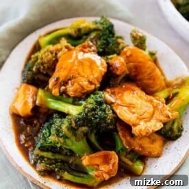 20 Quick Chicken Dinners for Busy Weeknight Meals 3 up close image of chinese chicken and broccoli on a ceramic plate on top of a light green linen towel