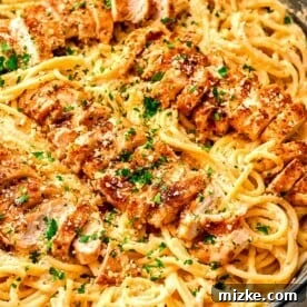 20 Quick Chicken Dinners for Busy Weeknight Meals 4 cajun chicken alfredo with sliced chicken on top of pasta in cast iron skillet