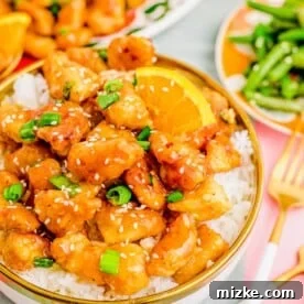 A bowl of orange chicken over white rice