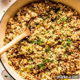 A pot of dirty rice mixed with ground meat, green bell peppers, and herbs